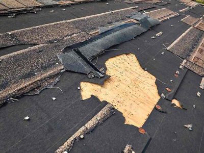 Damaged plywood roof decking beneath shingles