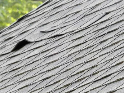Roof shingles showing curling edges and granule loss