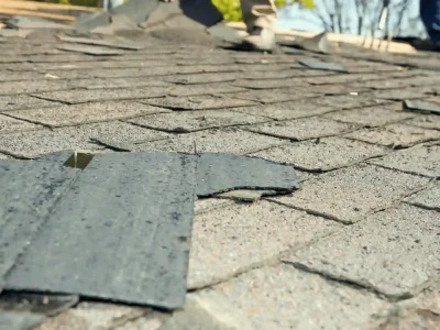 Cracked and lifting asphalt shingles with granule loss showing extreme heat damage