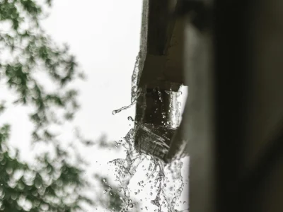 Water overflowing from clogged gutters during heavy rain in Northwest Arkansas