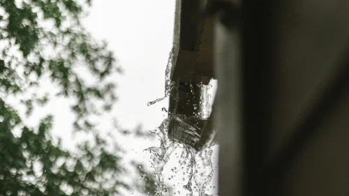 Water overflowing from clogged gutters during heavy rain in Northwest Arkansas