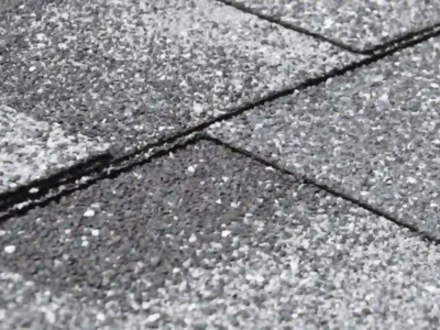Weathered roof shingles with white residue and granule loss indicating hidden water damage in Northwest Arkansas