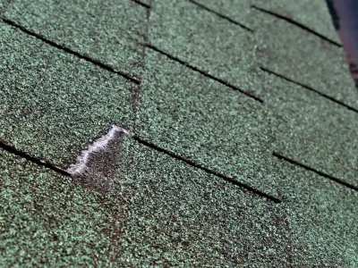Asphalt roof shingles showing weather-related wear from heat and UV exposure