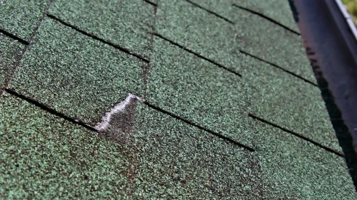 Asphalt roof shingles showing weather-related wear from heat and UV exposure