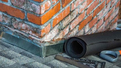 Roof cricket flashing installed behind a brick chimney