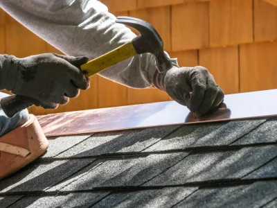Contractor repairing metal flashing on a residential roof