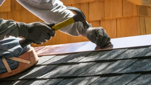 Contractor repairing metal flashing on a residential roof