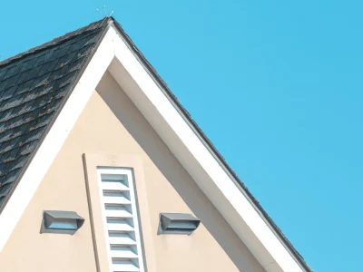 Steep pitch residential roof with gable vents showing roof angle and drainage design in Northwest Arkansas