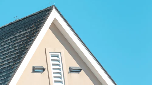 Steep pitch residential roof with gable vents showing roof angle and drainage design in Northwest Arkansas