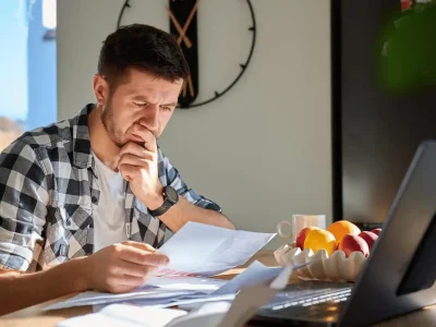 Homeowner reviewing roofing contractor estimate and repair documents at home