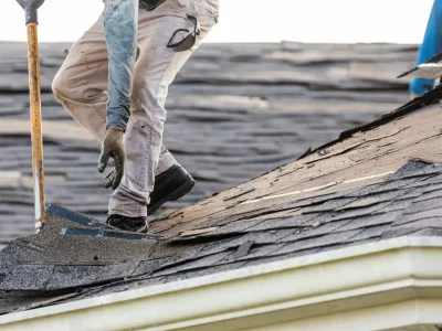 Roofer inspecting a storm-damaged roof in Arkansas