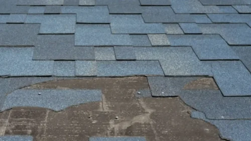 Deteriorating roof shingles showing age and weather damage