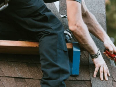 Roofer securing and preparing asphalt shingles for storm season in Northwest Arkansas