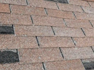 Roof shingles showing uneven wear and aging patterns caused by sun and moisture exposure