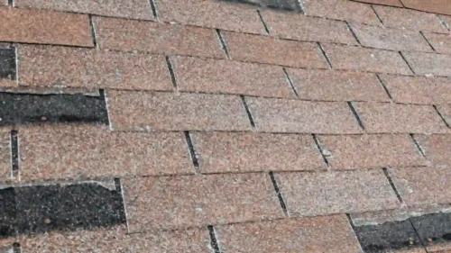 Roof shingles showing uneven wear and aging patterns caused by sun and moisture exposure